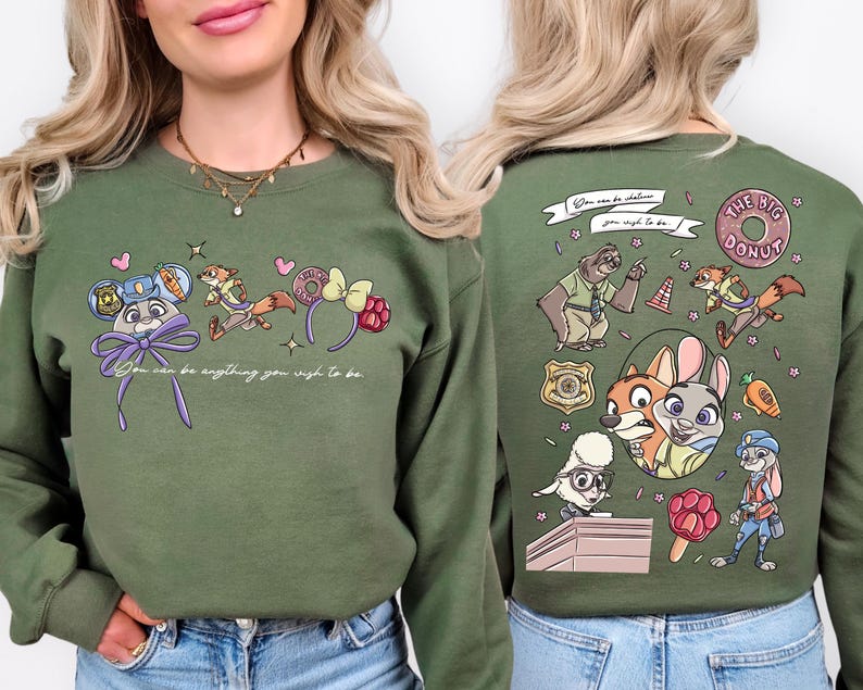 A woman wearing a green sweater with a cartoon character design on the front and the back featuring various cartoon characters and text.