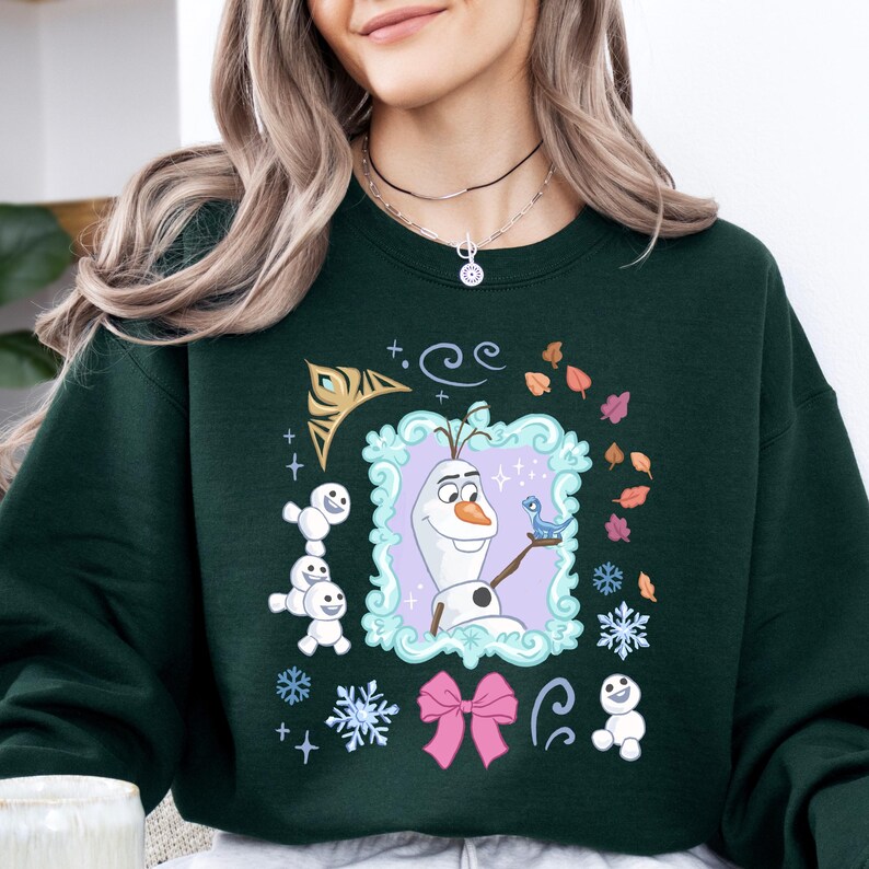 A woman wearing a green sweatshirt with a graphic of Olaf from the Disney movie Frozen.