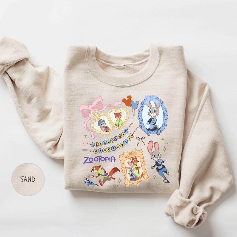 A beige sweatshirt with a colorful graphic design featuring various cartoon characters, including a rabbit, a fox, and other animals, along with a heart and the word "Zoobia".