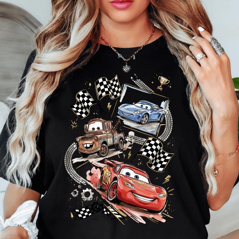 A woman wearing a black t-shirt with a graphic design featuring characters from the animated movie Cars.