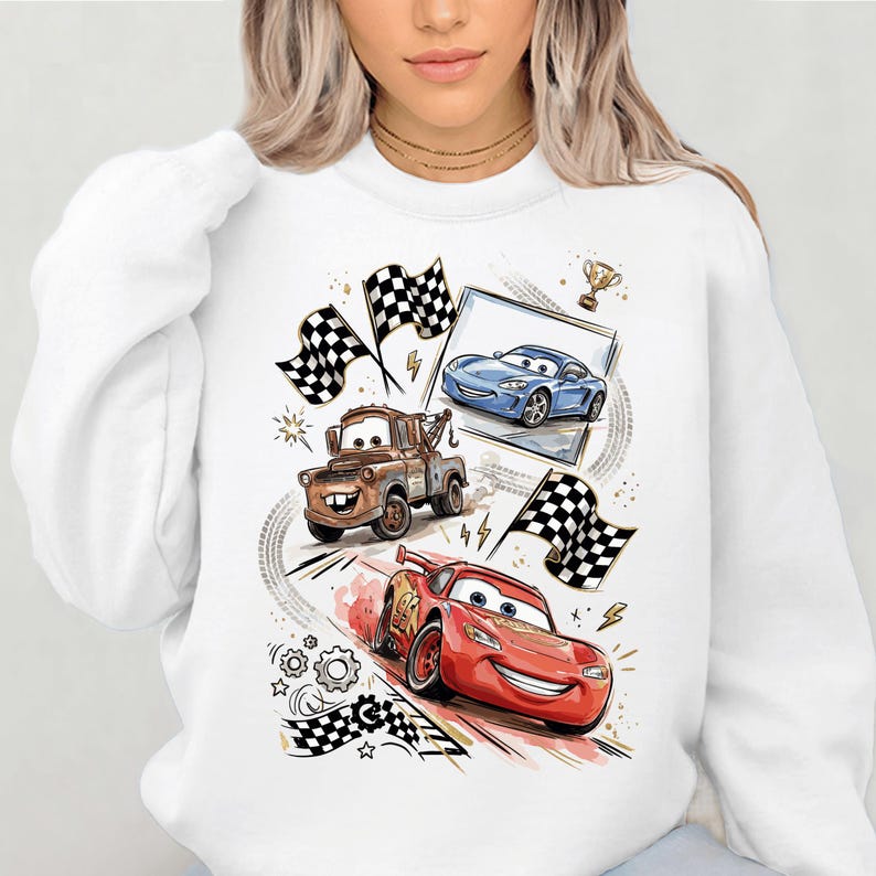 A white sweatshirt with a graphic design featuring characters from the animated movie Cars, including a tow truck, a blue car, and a red car.