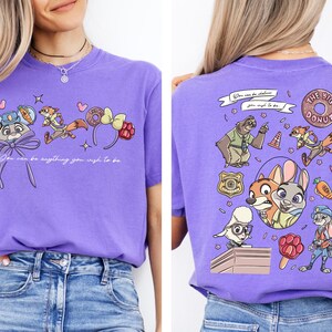 a woman wearing a purple t-shirt with a cartoon character design on the front and back.