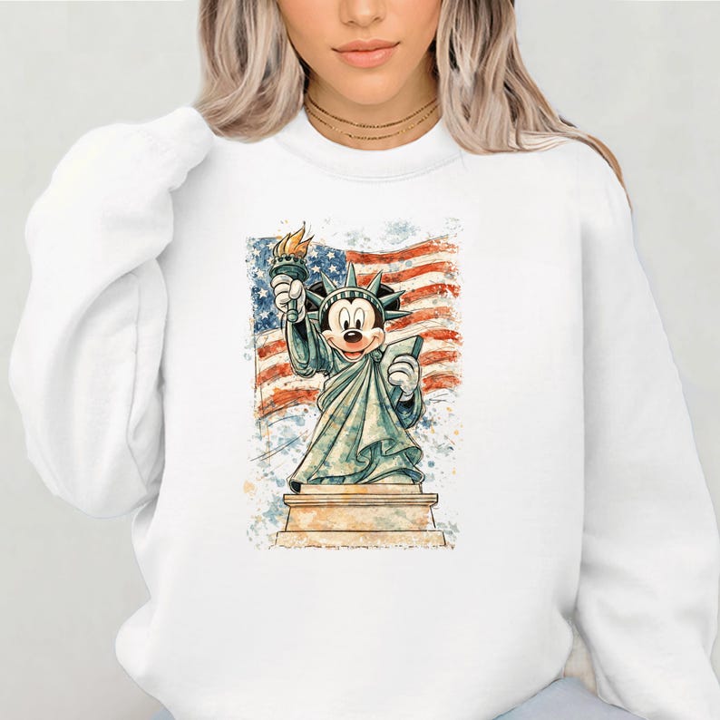 A woman wearing a white sweatshirt with a graphic of Mickey Mouse holding the American flag.