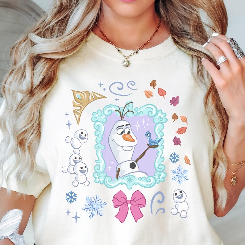 A woman wearing a white t-shirt with a graphic design featuring characters from the Disney movie Frozen.