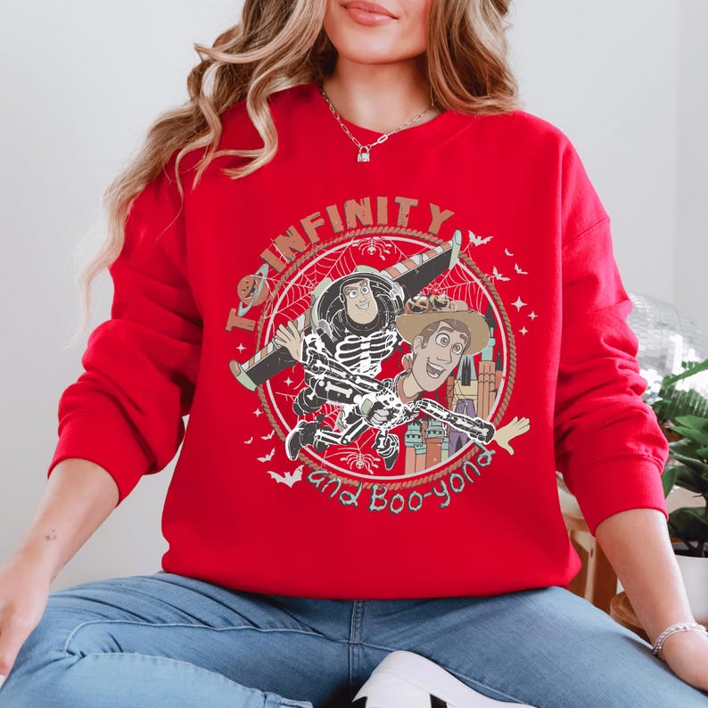 A woman wearing a red sweatshirt with a graphic design featuring characters from the Toy Story franchise.