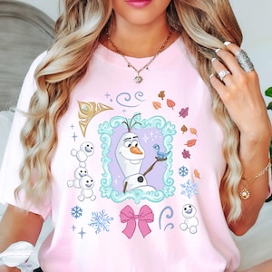 A woman wearing a pink t-shirt with a graphic of Olaf from the Disney movie Frozen.