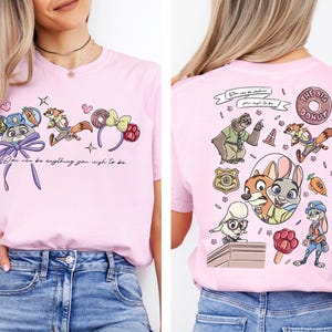 a woman wearing a pink t-shirt with a cartoon character design on the front and a back view of the same design.