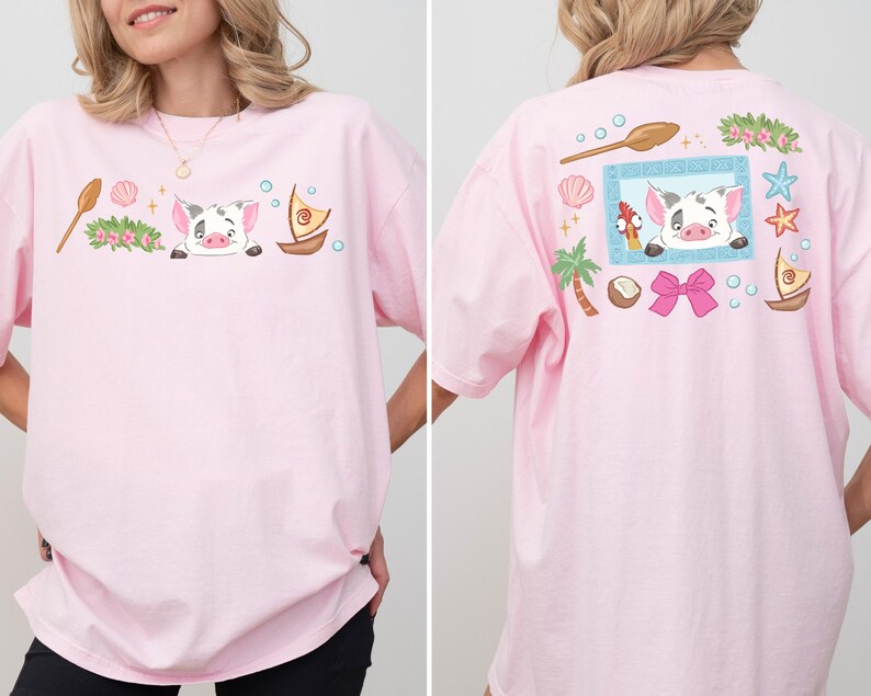 A woman wearing a pink t-shirt with a cartoon pig and various other cartoon-style objects and characters on it.