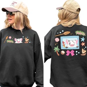 A woman wearing a black sweatshirt with a cartoon pig design and various other decorative elements on the back.