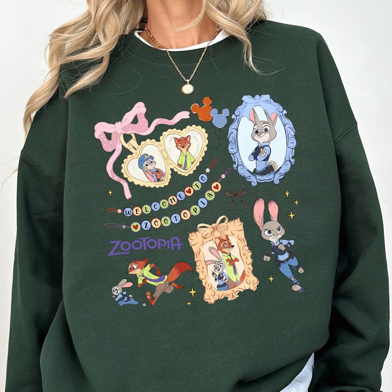 A green sweatshirt with various cartoon animal characters and a decorative frame, along with a necklace and a pendant.