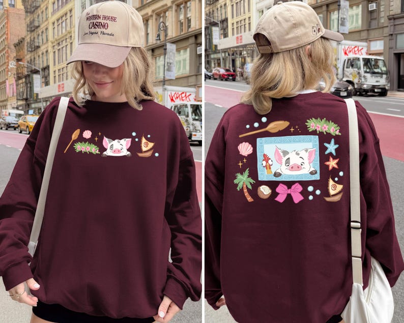 A woman wearing a maroon sweater with a cartoon pig design and various other decorations on the back.