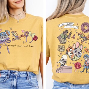 a woman wearing a yellow t-shirt with a cartoon character design on the front and a back view of the same design.