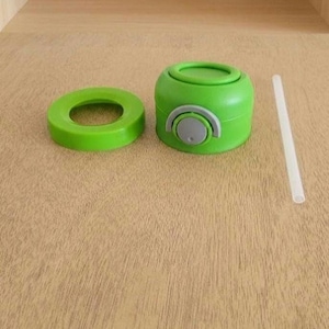 Puede incluir: Una botella de agua verde con una tapa verde a juego y un bot&oacute;n gris. La botella est&aacute; desmontada, con la tapa y un anillo verde separados. Tambi&eacute;n se incluye una pajita transparente.