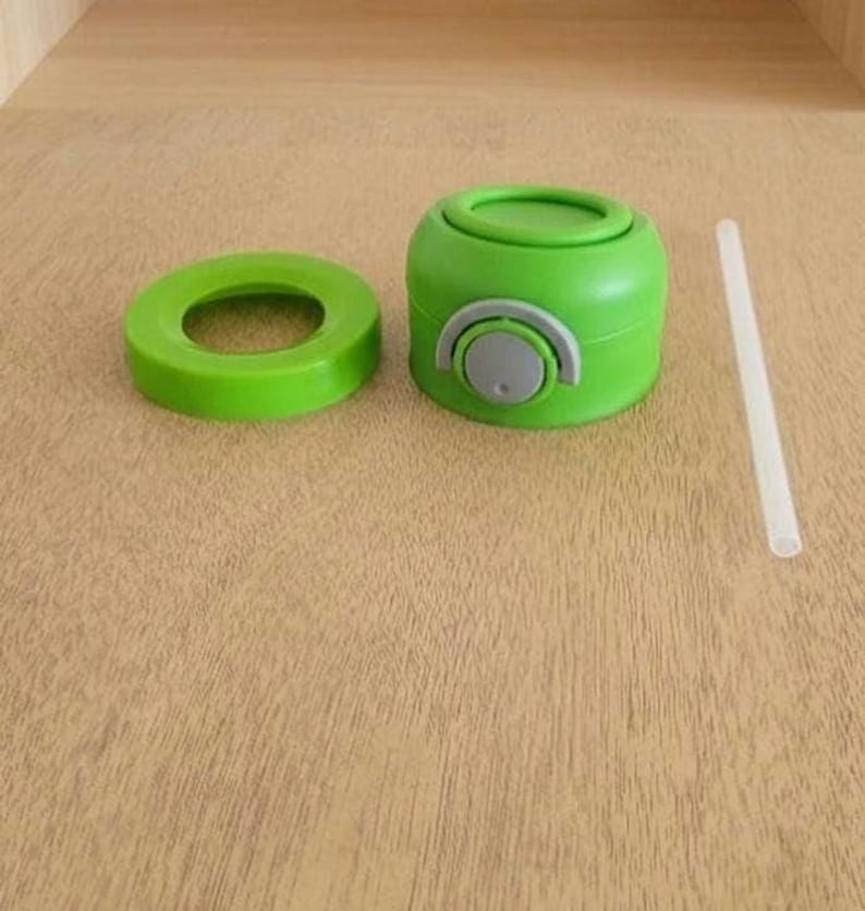 Puede incluir: Una botella de agua verde con una tapa verde a juego y un bot&oacute;n gris. La botella est&aacute; desmontada, con la tapa y un anillo verde separados. Tambi&eacute;n se incluye una pajita transparente.