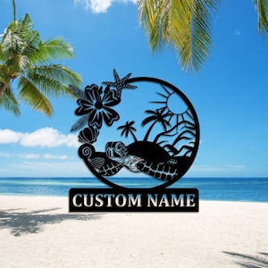 Op de afbeelding: Zwarte metalen silhouet van een schildpad die in de oceaan zwemt met palmbomen, een bloem en een zeester. De tekst "CUSTOM NAME" staat onder de silhouet.