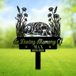 May include: Black metal garden memorial with a silhouette of a dog lying down. The memorial reads "In Loving Memory Of MAX 2016-2025".