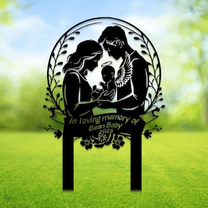 May include: Black metal silhouette of a family with a baby in a wreath with the text "In loving memory of Bean Baby 2025".