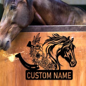 May include: Black silhouette of a horse head with a horseshoe and floral design. The text "CUSTOM NAME" is below the design.