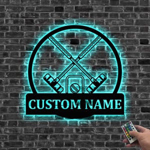 Könnte beinhalten: Ein schwarzes Metallschild mit einem neongrünen Leuchten, das ein Paar gekreuzte Krocket-Schläger und einen Ball zeigt. Das Schild hat Platz für einen individuellen Namen, der "CUSTOM NAME" lautet.