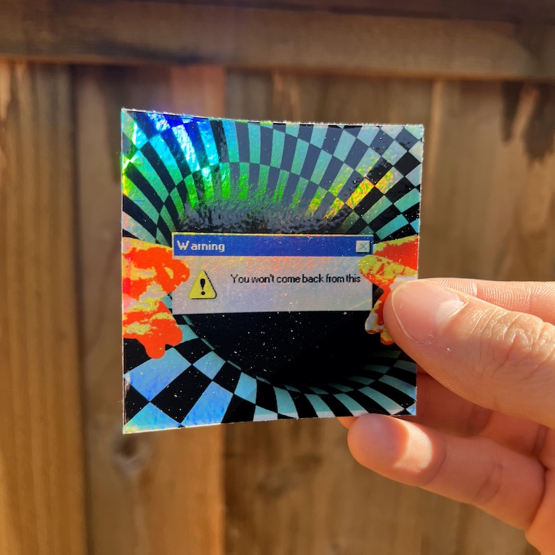 May include: A square holographic sticker featuring a black and white checkered vortex pattern. In the centre, a digital pop-up window displays the text 'Warning' and 'You won't come back from this' next to a yellow triangle exclamation icon.