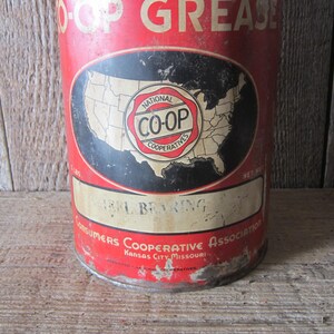 K&ouml;nnte beinhalten: Vintage rote und wei&szlig;e Metall-Dose mit CO-OP-Fett. Die Dose hat ein schwarzes Oval mit einer Karte der Vereinigten Staaten und dem CO-OP-Logo. Die Dose tr&auml;gt auch die Aufschrift "Heavy Bearing" und "Consumers Cooperative Association Kansas City Missouri."