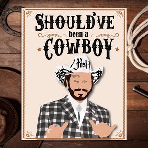 May include: A white and black checkered print blazer with a white cowboy hat. The hat has the word "Post" written on it. The text "Should've been a COWBOY" is written in black on a white background with a brown border.