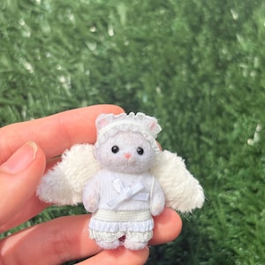 May include: A handmade wooden sign with the text "Welcome" in a playful font. The sign features a distressed white background and a dark brown border. A small, decorative heart is attached to the bottom.