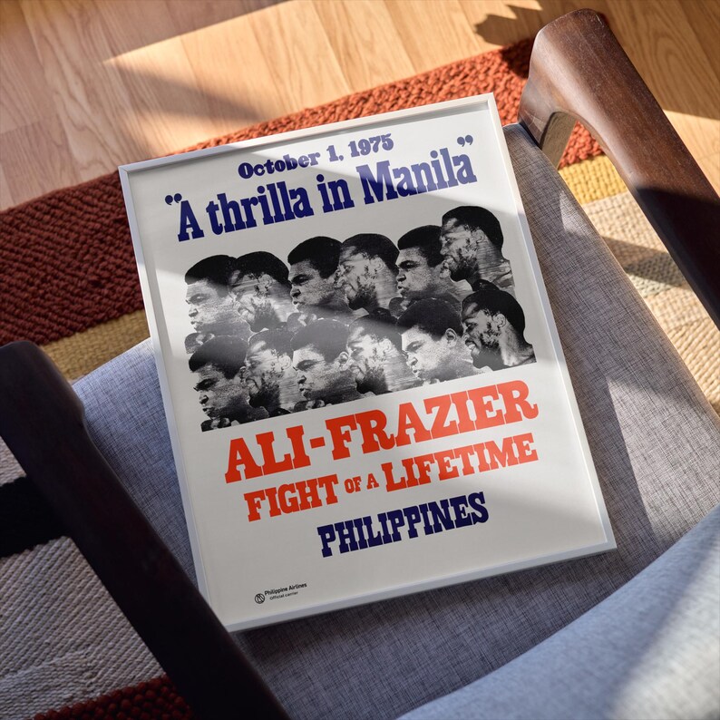Op de afbeelding: Een witte poster met blauwe en rode tekst die "October 1, 1975 "A thrilla in Manila" ALI-FRAZIER FIGHT OF A LIFETIME PHILIPPINES" luidt. De poster toont een collage van zwart-witfoto's van boksers.