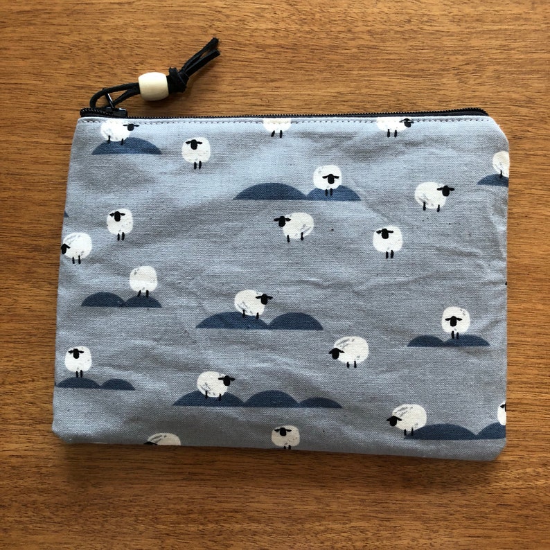 Sheep newspaper from the panorama cloue collection zippered pouch