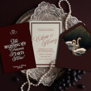 May include: A wedding invitation suite featuring a deep burgundy card with white text reading The Beginning of Forever Starts Here, a cream-coloured card with burgundy text for Olivia & Henry, and a burgundy envelope with a swan illustration.