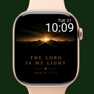 Op de afbeelding: Een roségouden smartwatch toont een berglandschap met een zonsondergang. De wijzerplaat toont de tijd, dinsdag de 21e, en de tekst "THE LORD IS MY LIGHT" met een kruis en Psalm 27:1.