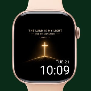 Op de afbeelding: Een roségouden smartwatch met een zwart scherm met de tekst "THE LORD IS MY LIGHT AND MY SALVATION PSALM 27:1" en een gloeiend kruis. De tijd is 10:09 uur op dinsdag de 21e.