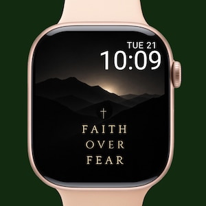 Op de afbeelding: Een roségouden smartwatch met een zwart scherm met de woorden "FAITH OVER FEAR" en een kruissymbool. De tijd is 10:09 uur op dinsdag de 21e. De horlogeband is lichtroze.