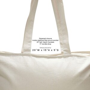 May include: Cream-colored tote bag with a zippered closure, 25-inch self-fabric handles, and an 11-inch handle drop. Features an inside zippered flap pouch pocket. Bag dimensions are 20"W x 15"H x 5"D.