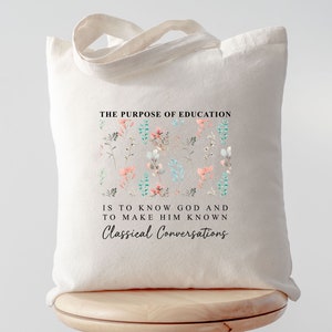 May include: A white canvas tote bag with a floral design and the text "THE PURPOSE OF EDUCATION IS TO KNOW GOD AND TO MAKE HIM KNOWN Classical Conversations".