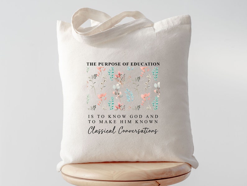 May include: A white canvas tote bag with a floral design and the text "THE PURPOSE OF EDUCATION IS TO KNOW GOD AND TO MAKE HIM KNOWN Classical Conversations".