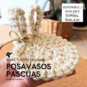 May include: A beige macrame coaster shaped like a bunny with gold ribbon ears. The coaster is in a hand and the text "Video Tutorial Macrame POSAVASOS PASCUAS By Mar de Comodoro" is below the coaster. The text "DISPONIBLE / AVAILABLE ESPAÑOL ENGLISH" is in the upper right corner of the image.