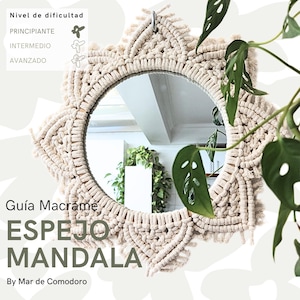 Könnte beinhalten: Ein weißer Makramee-Spiegel mit Mandala-Design. Der Spiegel hängt an einer Wand und hat einen Holzrahmen. Der Text "Guia Macrame ESPEJO MANDALA By Mar de Comodoro" steht unter dem Spiegel.