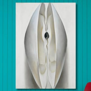 Puede incluir: Una pintura abstracta con una forma blanca y orgánica sobre un fondo claro cuelga de una pared turquesa. Un sillón rojo y una lámpara de pie blanca con una pantalla blanca están en la habitación. El suelo es blanco.