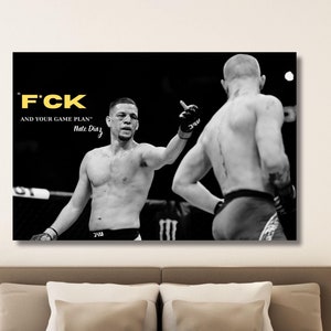 以下が含まれることがあります： リングにいる2人の上半身裸のMMAファイターが描かれた白黒のキャンバスプリント。プリントには「F*CK AND YOUR GAME PLAN」というテキストと「Nate Diaz」という名前が黄色で含まれています。