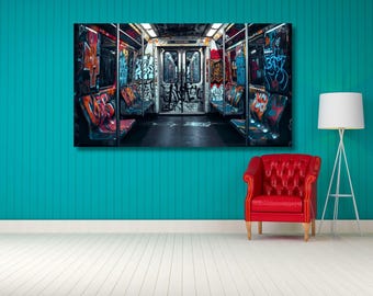 May include: A rectangular wall art print depicting the interior of a subway carriage covered in colourful graffiti. The scene features rows of seats, metal poles, and closed doors, all heavily tagged with various spray-painted designs and lettering.