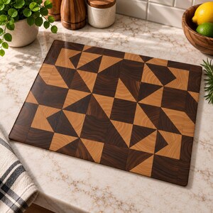 Puede incluir: Una tabla de cortar rectangular de madera con un patrón geométrico de segmentos triangulares y cuadrados de madera en tonos marrón oscuro y bronceado claro, dispuestos en un diseño de mosaico repetitivo.