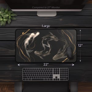 K&ouml;nnte beinhalten: Eine schwarze und goldene Mausmatte mit einem Design aus drei wei&szlig;en Koi-Fischen, die in einem wirbelnden Muster schwimmen. Die Mausmatte ist 22 Zoll breit und 12 Zoll hoch. Der Text "Large" ist auf der Mausmatte gedruckt.