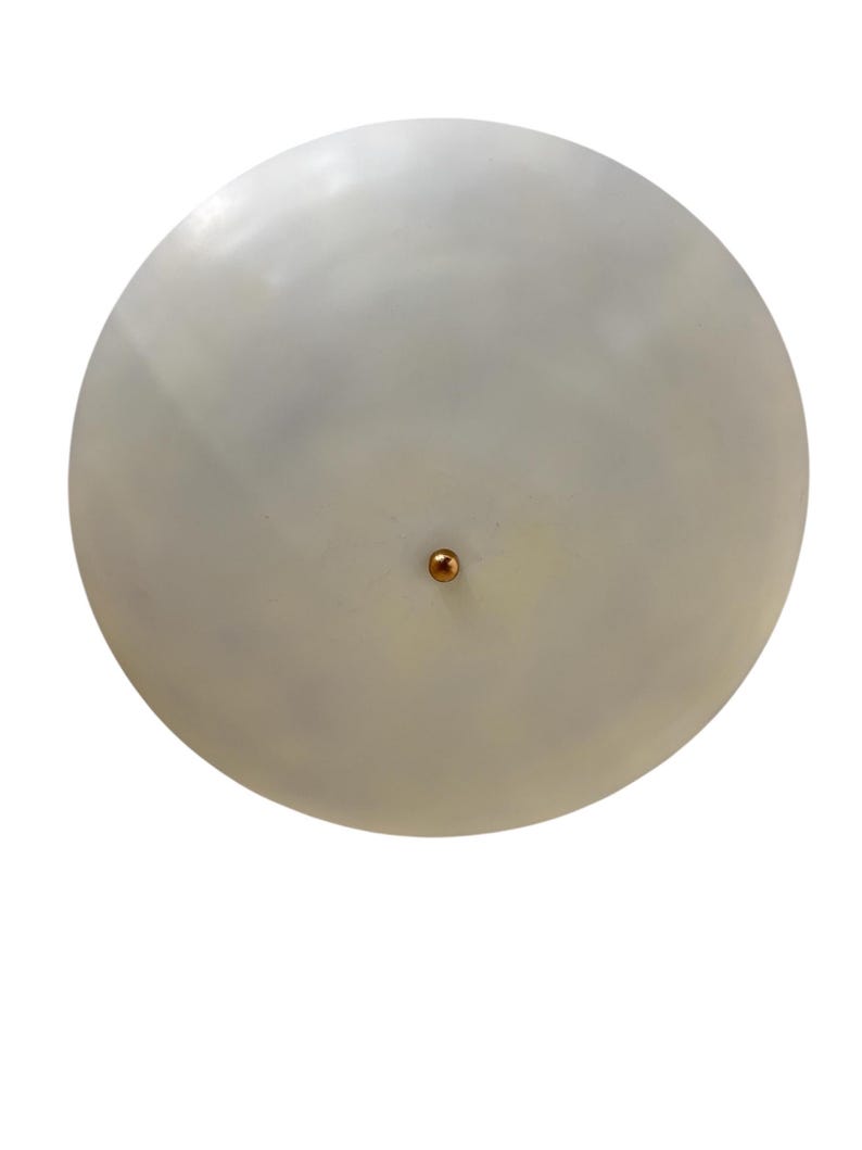 May include: A round, off-white ceiling light fixture with a copper-colored central accent. The light has a smooth, matte finish and a simple, minimalist design. The fixture is suitable for various interior design styles.