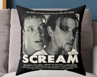 May include: Black and white throw pillow featuring a movie poster for the film "Scream" with the actors David Arquette and Neve Campbell. The text on the pillow reads "The Highly Acclaimed New Thriller From Wes Craven" and "Scream".