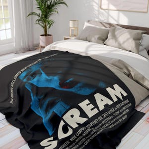 Può includere: Un poster in bianco e nero per il film "Scream" con un primo piano del viso di una donna con uno schema di colori blu e rosso. Il testo "Scream" è in grandi lettere bianche.