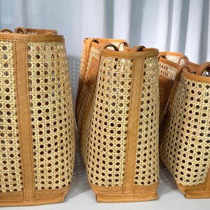 Three woven baskets with a light brown color and a pattern of small holes arranged in a row.
