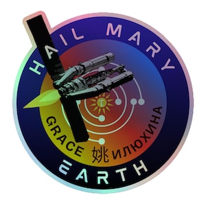 Op de afbeelding: Een ronde sticker met een ruimtethema. De sticker toont een ruimteschip, de woorden "HAIL MARY" en "EARTH" en andere tekst in meerdere talen. De achtergrond loopt over van blauw naar rood.