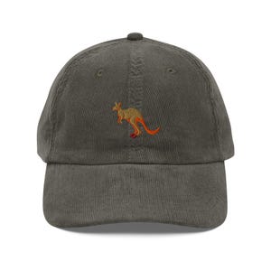 May include: A dark green corduroy baseball cap with an embroidered kangaroo in orange and yellow.