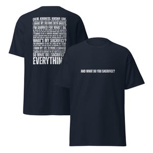 May include: Two navy blue t-shirts. The first shirt has a list of words and phrases in white, including "Calm, Kindness, Kinship, Love." The second shirt has the text "And what do you sacrifice?" in white.